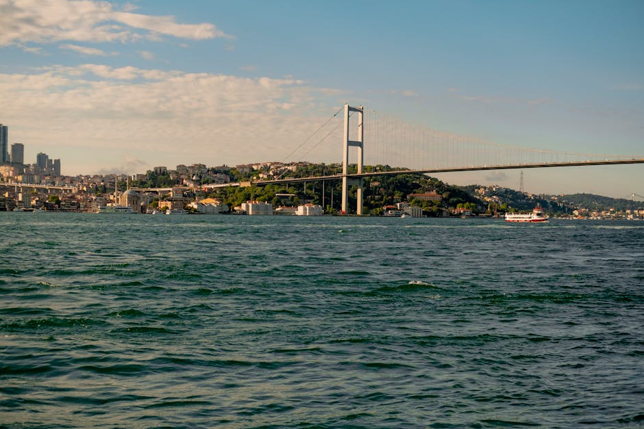 View of the Bosphorus Bridge connecting two continents in Istanbul, Turkey, with cityscape and water in foreground.