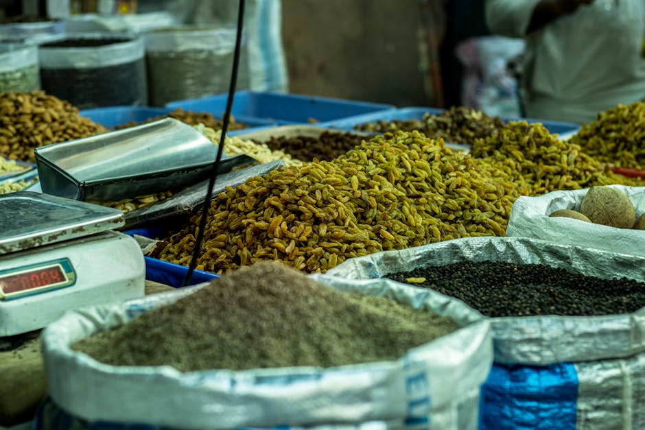 A vibrant spice market stall in Delhi displaying various spices and grains in sacks.