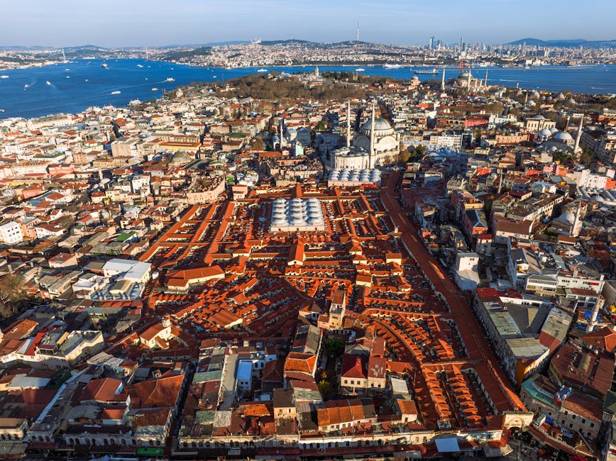 Captivating aerial view of Istanbul showcasing the Grand Bazaar and Nuruosmaniye Mosque with the Bosphorus in the background.